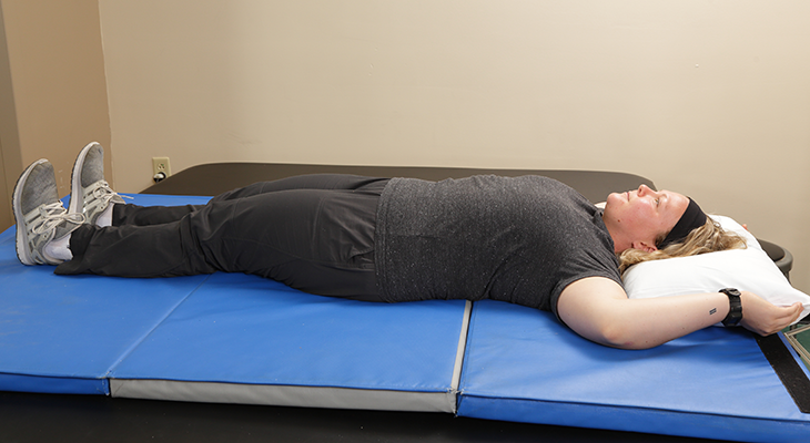 A patient demonstrates gluteal sets back pain exercises.