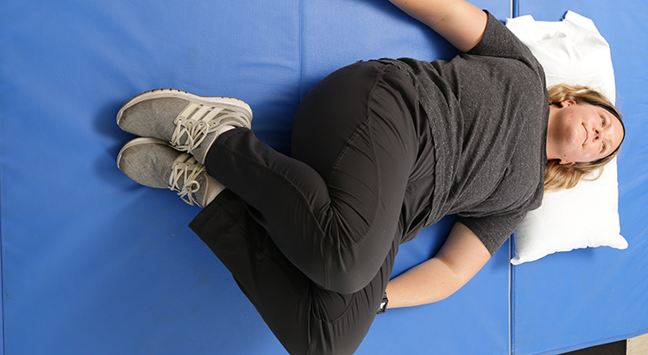 A patient demonstrates a lower trunk rotation to the left back pain exercise.