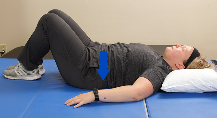 A patient demonstrates the transverse abdominus set back exercise.