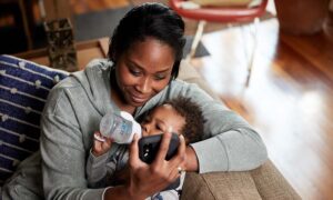 A woman and her child on an eCare video visit on a mobile phone through MyNortonChart